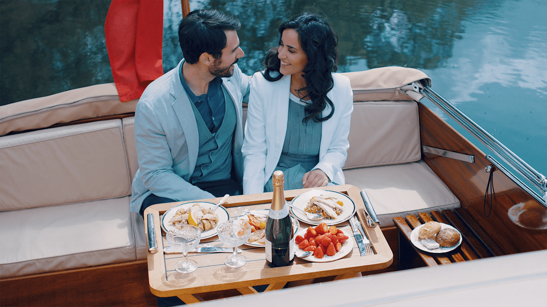 Man and Woman look at each other while eating a meal on a boat