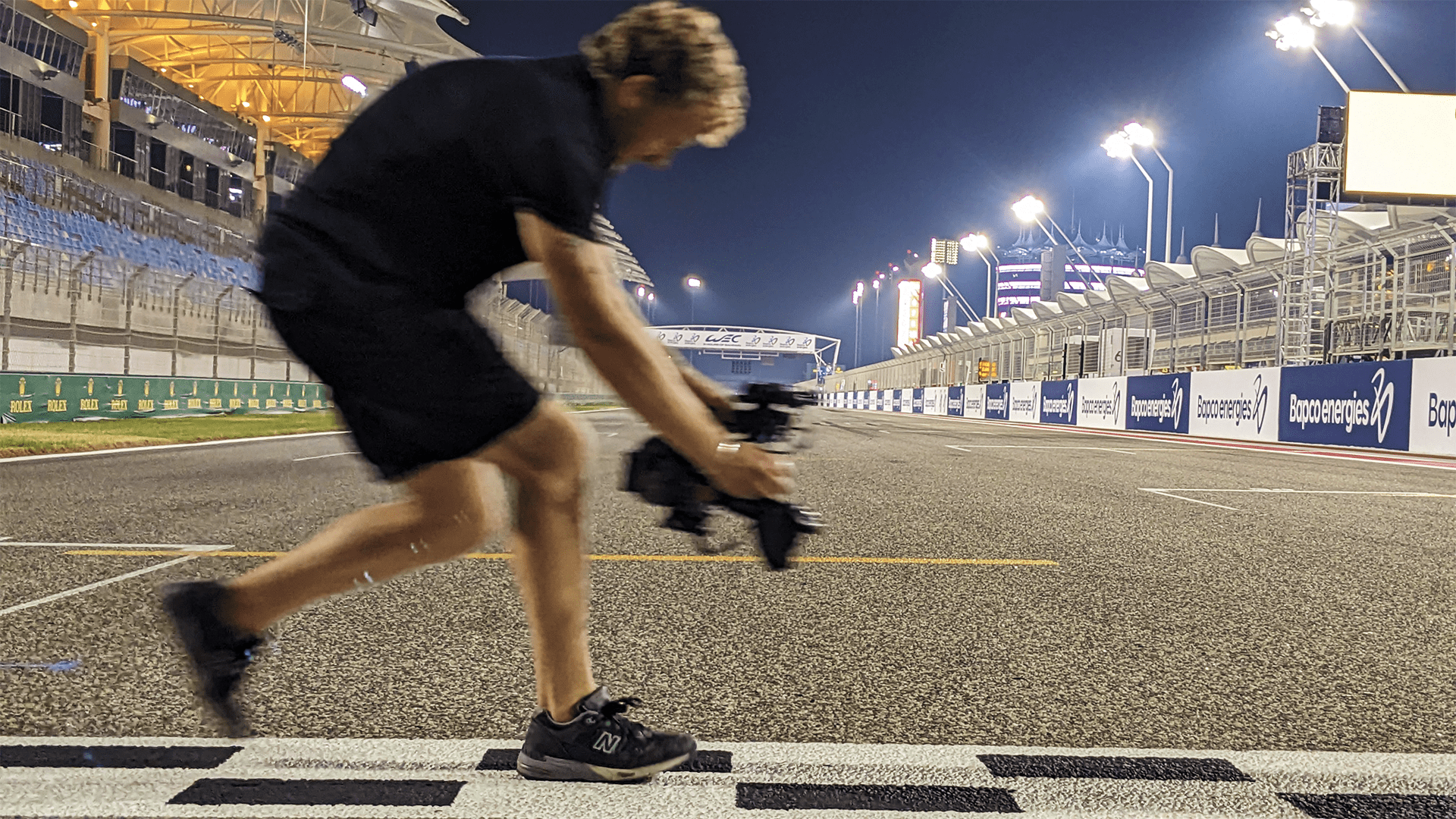 Man runs across Motorsport finish line with camera