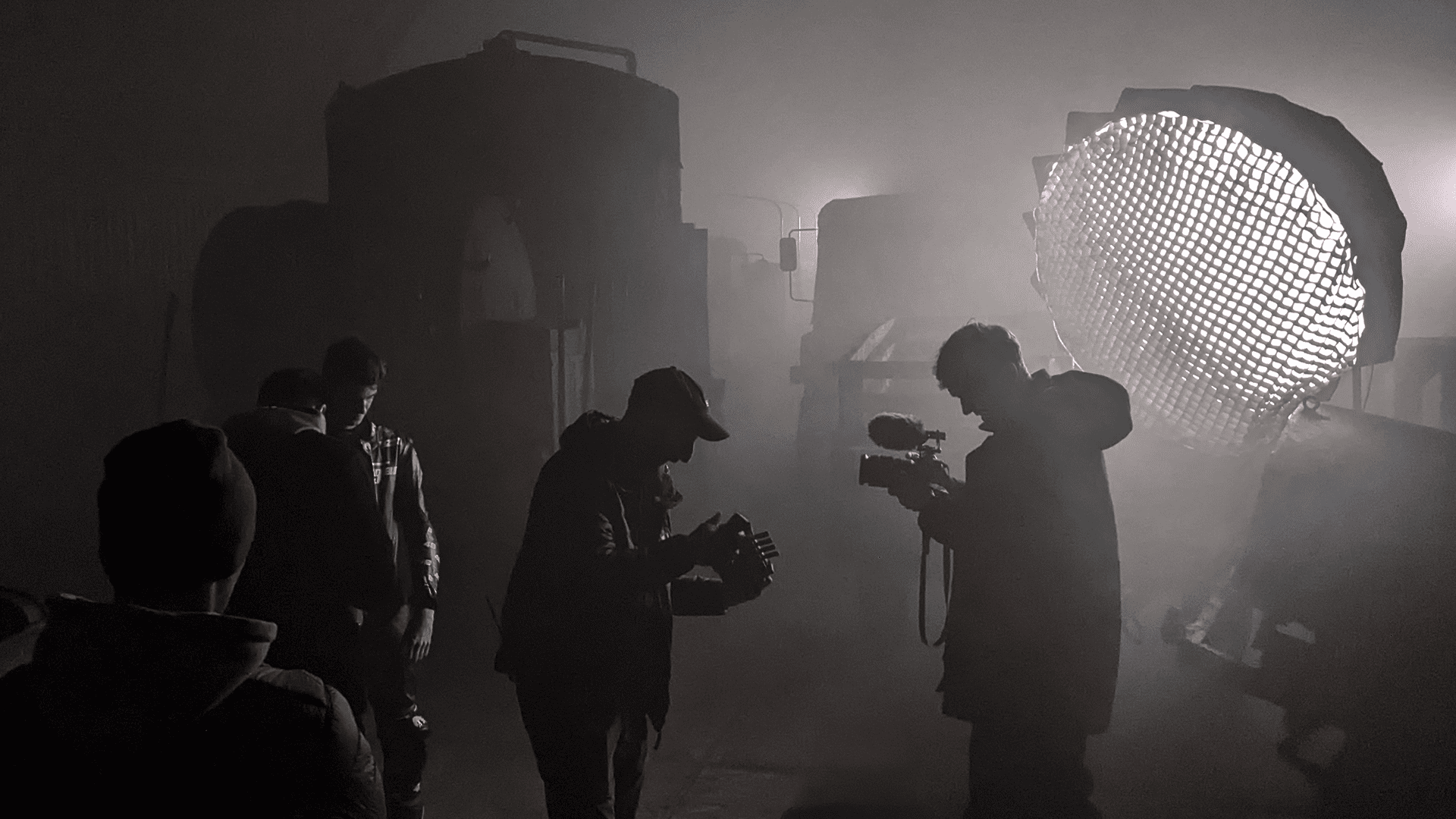 Camera Crew films in dark smokey environment with lighting setup